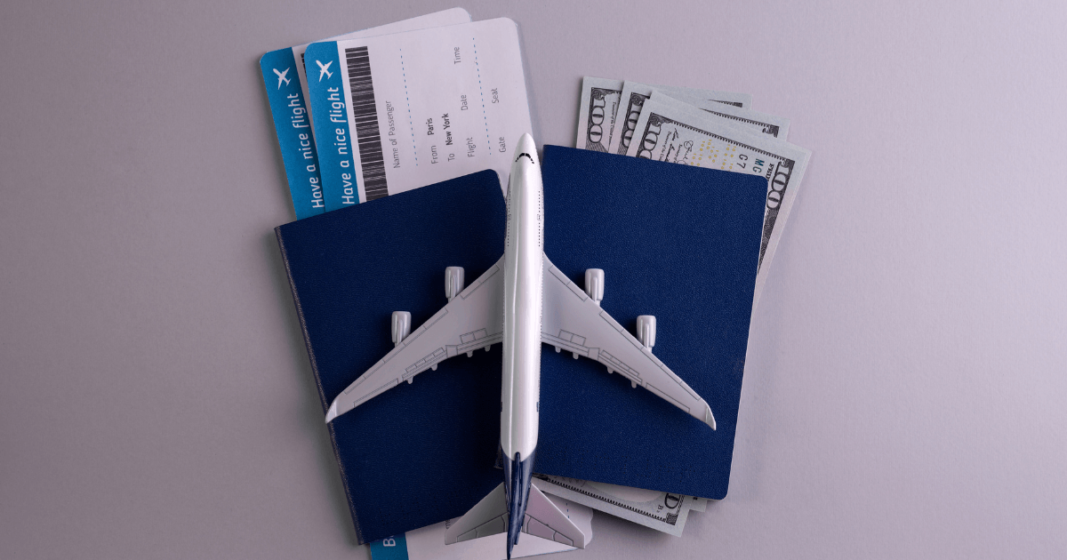 Pasaportes, billetes de avión y dinero para planificar el proceso de cambiar de estatus en Canadá.